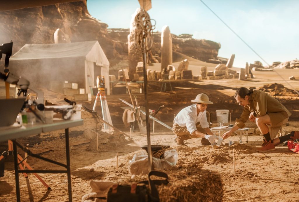 Archaeological Digging Site: Two Great Archeologists Work on Excavation Site, Cleaning Cultural Artifacts with Brush and Tools. Discovery of Ancient Civilization Temple, Architecture, Fossil Remains
